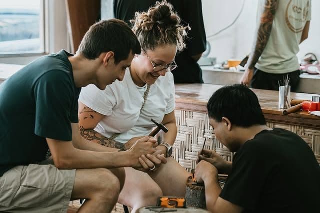 A group of friends laughing while shaping their pieces