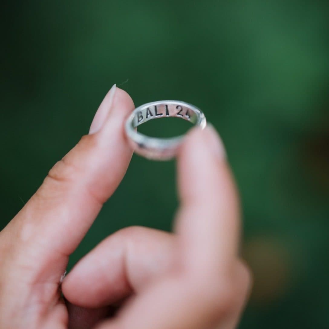 A student holding up the silver ring she made, engraved BALI 24